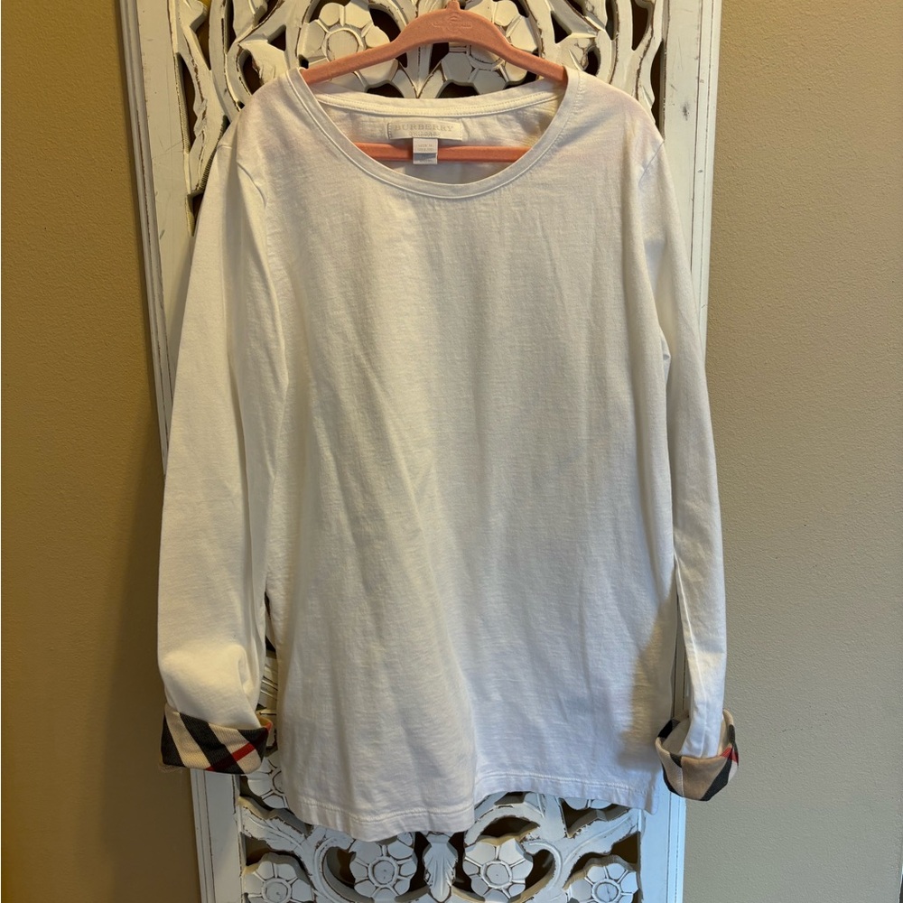 Burberry girls solid white top with pattern cuff trim.
